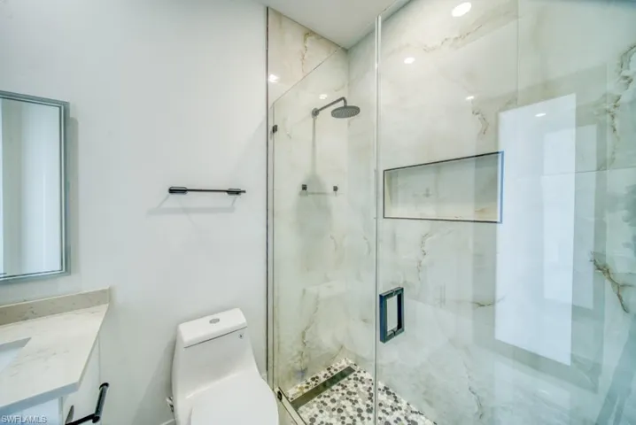 Bathroom with a marble finish shower and vanity