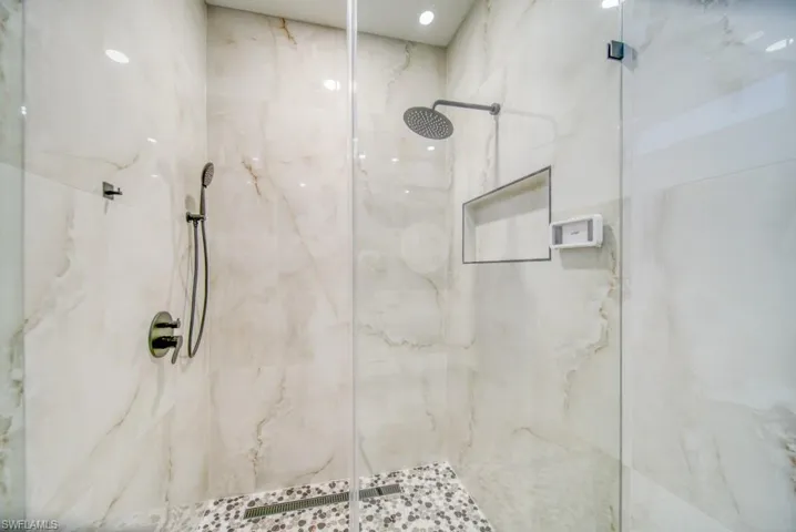 Full bathroom with a marble finish shower