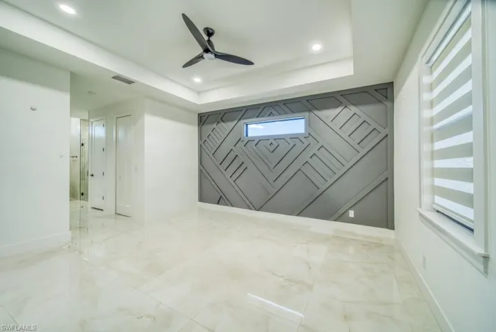 Spare room featuring a ceiling fan, a raised ceiling, and recessed lighting