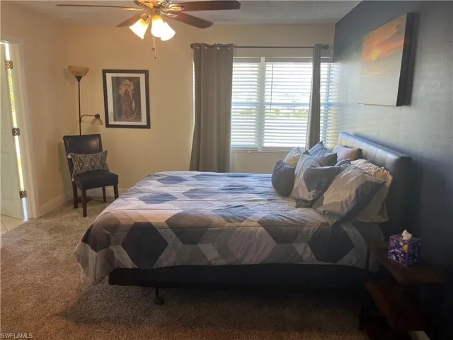 Bedroom with light carpet and a ceiling fan