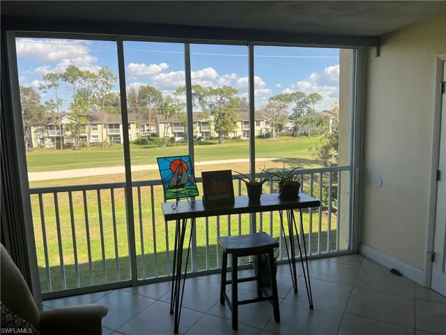 Sunroom with healthy amount of natural light, a residential view, and view of golf course