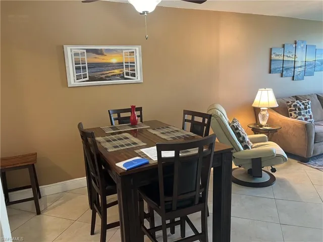 Dining area with light tile patterned floors and a ceiling fan