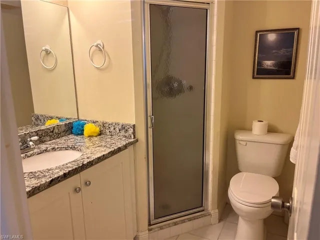 Full bath with vanity, a stall shower, and light tile patterned floors