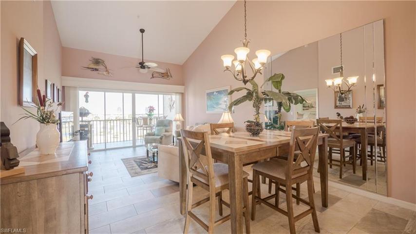 Vaulted ceilings, newer tile floors, and decorative mirrors welcome you into the dining and living areas.
