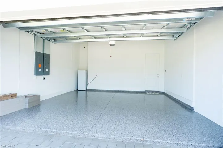 Garage with electric panel and baseboards