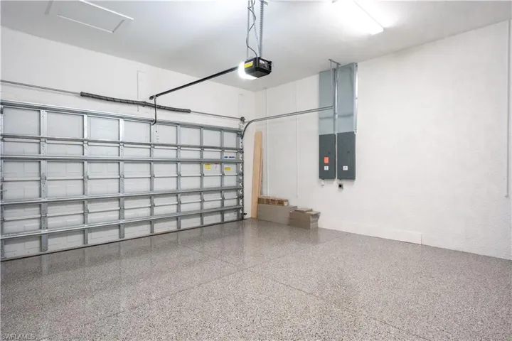 Garage featuring electric panel and a garage door opener