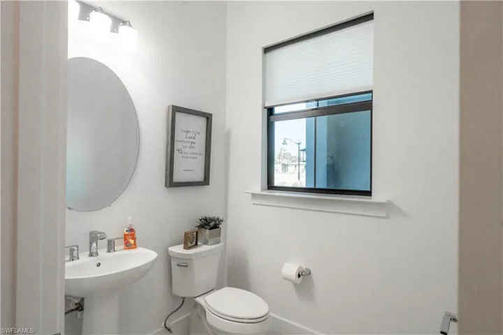 Half bath with toilet, baseboards, and a sink