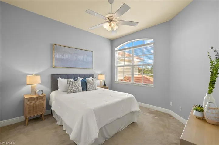 Bedroom with ceiling fan, carpet floors, and baseboards