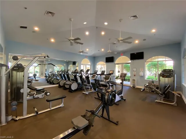 Exercise room with a ceiling fan, recessed lighting, baseboards, and vaulted ceiling