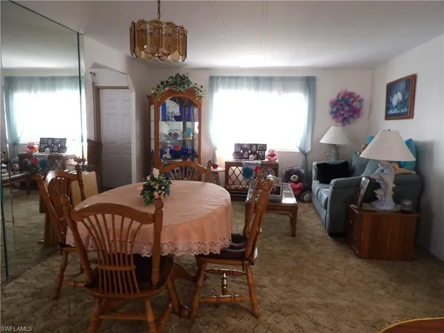 Dining area with carpet flooring and a chandelier