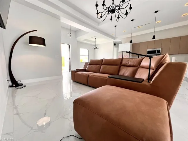 Open-concept living space showcasing white tile flooring with subtle veining