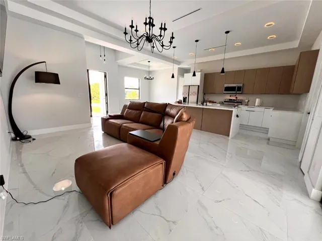 Open-concept living area with large format marble-look tile flooring