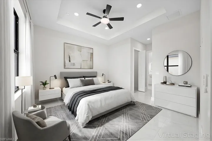 Bedroom featuring recessed lighting, ceiling fan, light marble finish flooring, and a raised ceiling
