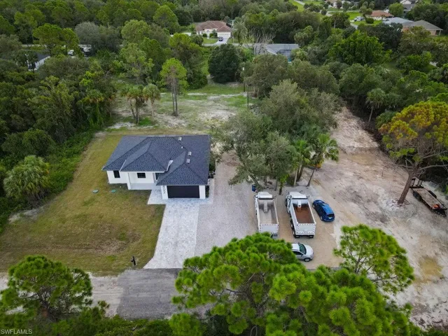 Aerial view of property and surrounding area with a tree filled landscape
