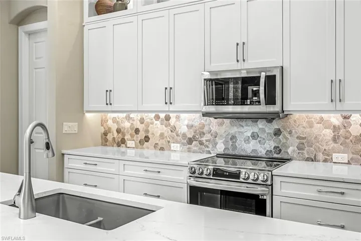 Quartz counters with a marble backsplash, blanco sink