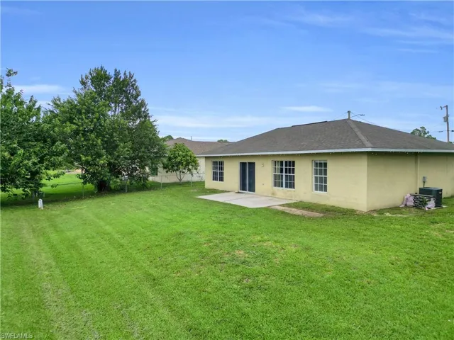 Back of property featuring a patio area, stucco siding, and a shingled roof