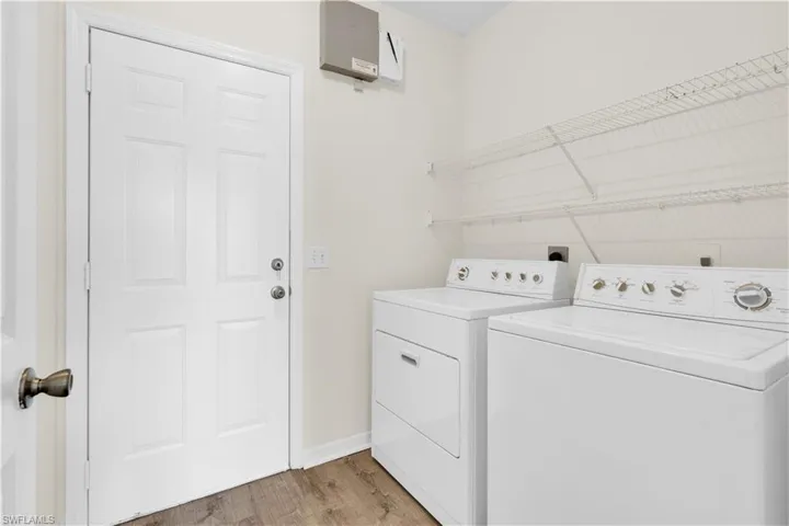 Laundry room with light wood finished floors and washing machine and dryer