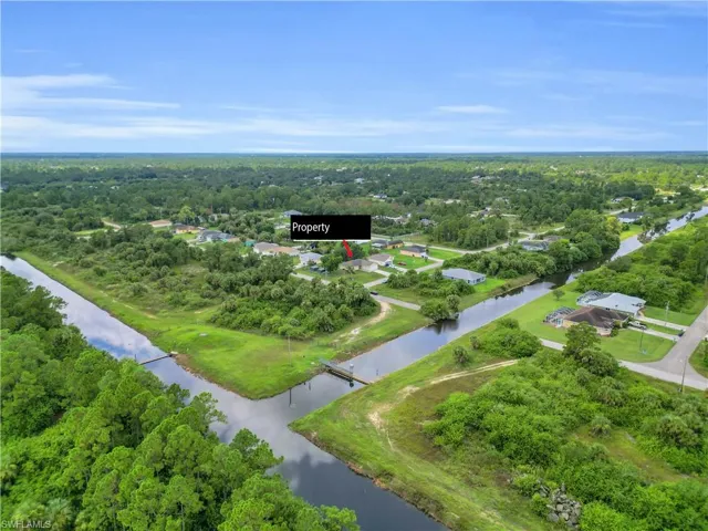 View of property location featuring a nearby body of water and a heavily wooded area