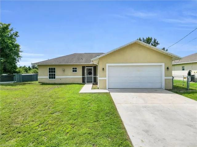 Ranch-style house with stucco siding, driveway, a garage, a gate, and a sunroom