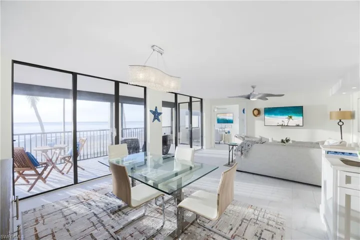 Dining area featuring a wall of windows, marble look tile flooring, and ceiling fan