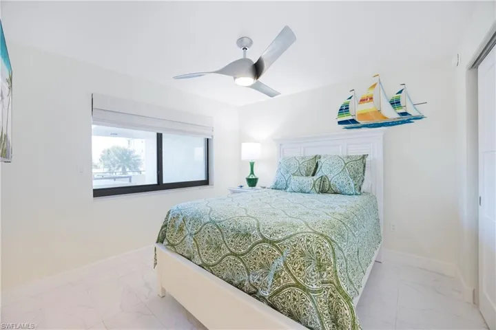 Bedroom with light marble finish floors and a ceiling fan