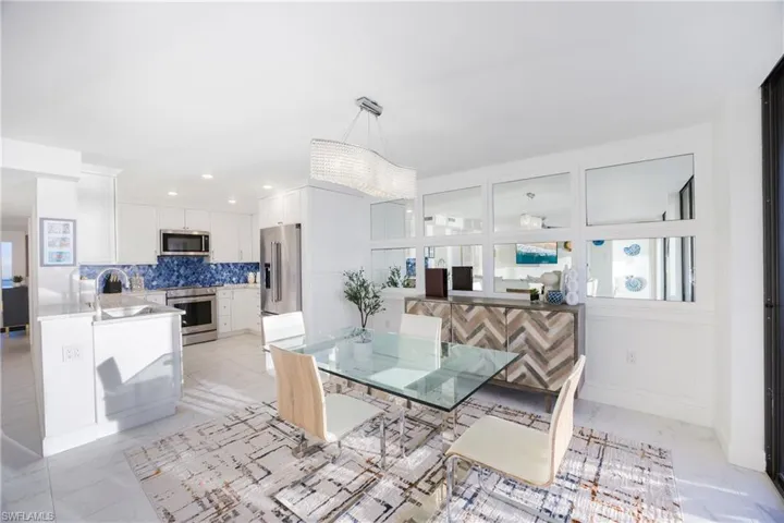 Dining area featuring light marble finish floors and recessed lighting