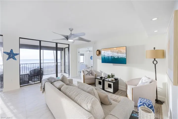 Living area with a wall of windows, recessed lighting, and ceiling fan