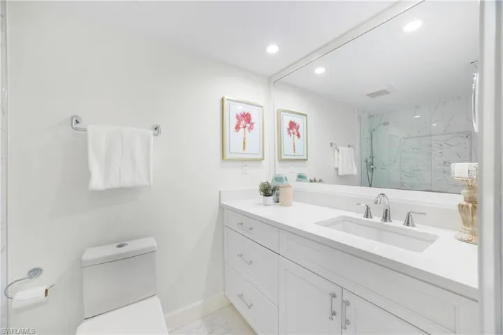 Full bathroom with light marble finish flooring, vanity, a marble finish shower, and recessed lighting