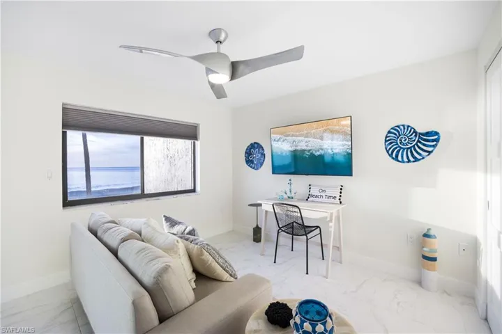 Office space with marble look tiles and a ceiling fan