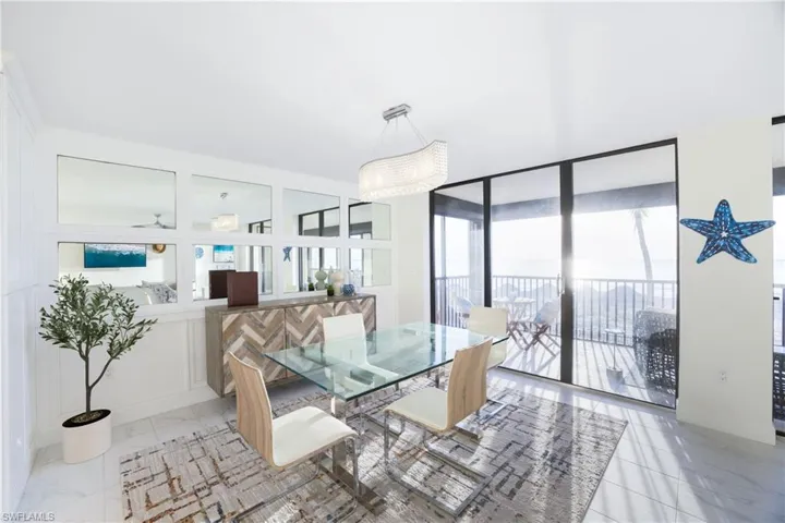 Dining space with healthy amount of natural light, light marble finish floors, and expansive windows
