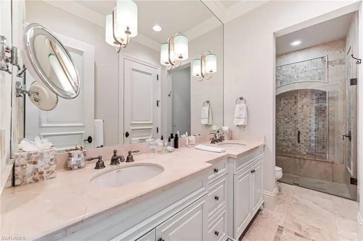 Bathroom featuring vanity, toilet, an enclosed shower, and ornamental molding