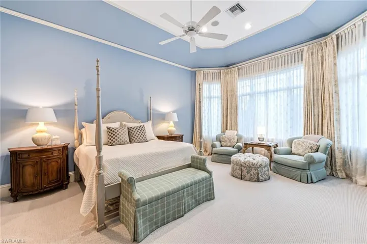 Carpeted bedroom with ceiling fan and crown molding