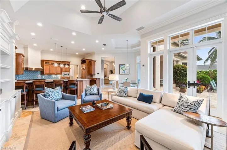 Living room featuring a tray ceiling, ceiling fan, and ornamental molding