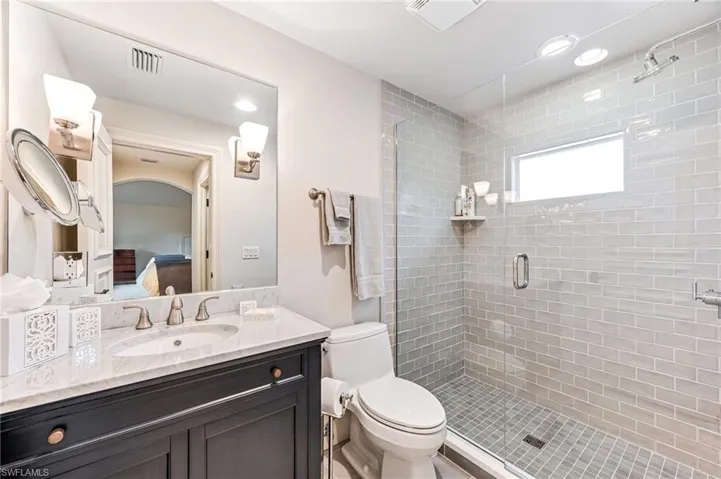 Bathroom with vanity, toilet, and an enclosed shower