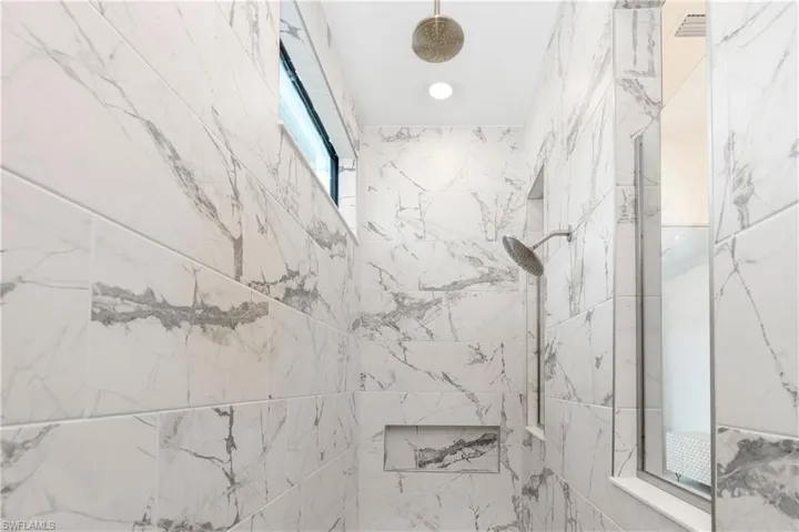 Full bathroom featuring a marble finish shower and recessed lighting