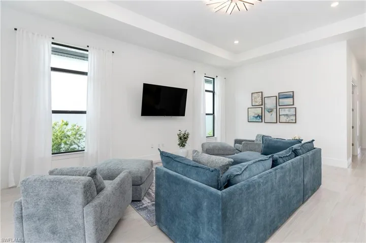 Living area featuring recessed lighting and a tray ceiling