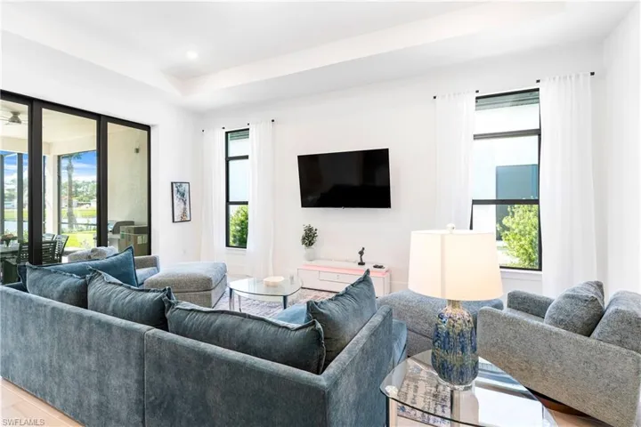Living area featuring wood finished floors, a tray ceiling, and recessed lighting