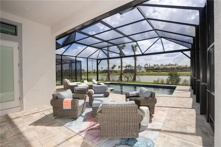 View of patio / terrace with a sunroom, a lanai, a water view, an outdoor pool, and an outdoor hangout area