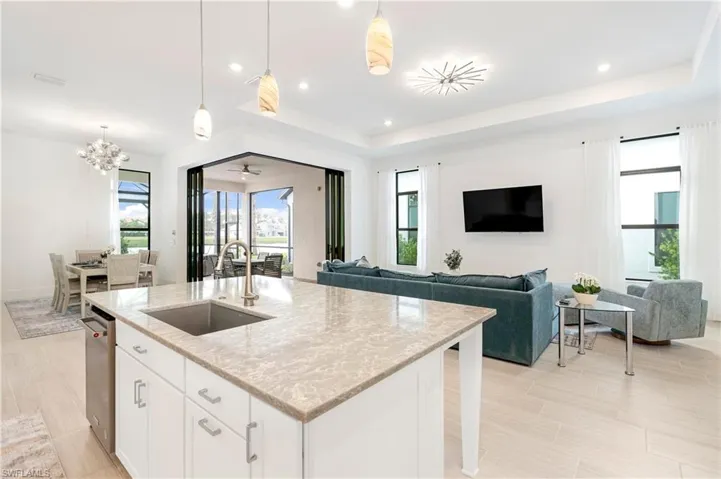 Kitchen featuring white cabinets, light stone countertops, decorative light fixtures, and recessed lighting