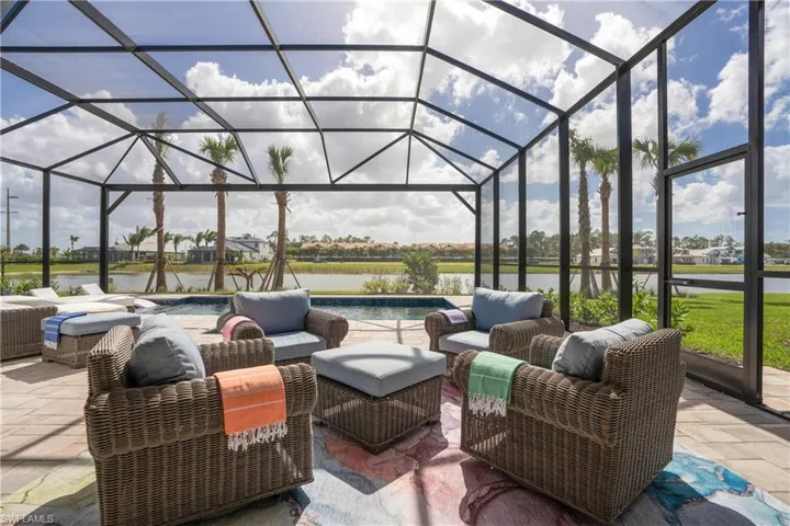 View of patio / terrace featuring glass enclosure, outdoor lounge area, and a water view