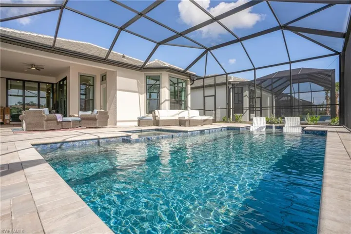 View of pool featuring a sunroom, glass enclosure, an outdoor hangout area, and a patio