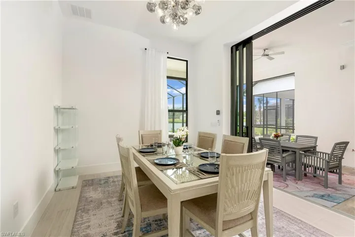 Dining space featuring a chandelier, ceiling fan, and light wood-type flooring