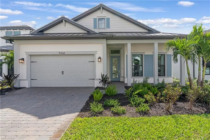 View of front of house featuring a porch, decorative driveway, and stucco siding