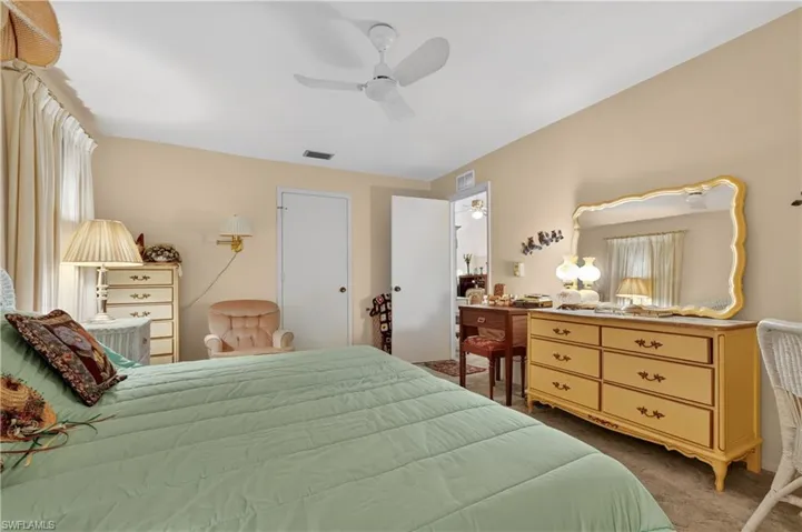 Recessed window with drapes, ceiling fan with integrated lighting, and carpeted flooring