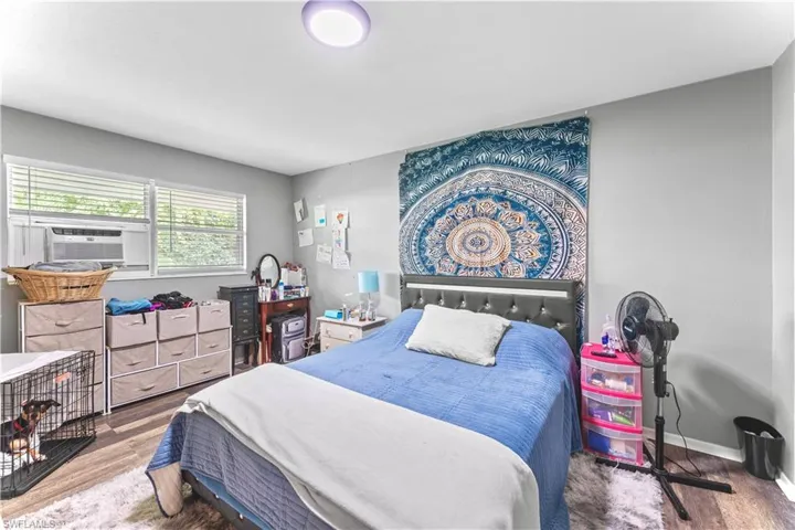 Bedroom with hardwood / wood-style flooring and cooling unit