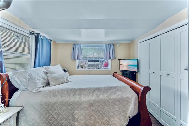 Bedroom featuring cooling unit, a closet, and hardwood / wood-style flooring