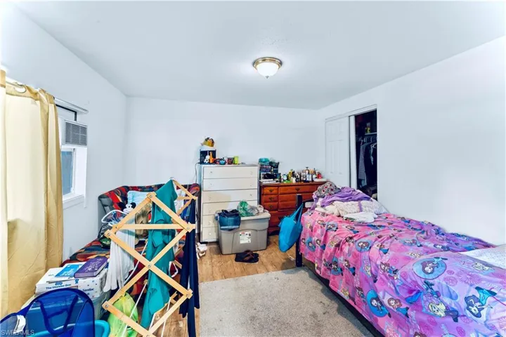 Bedroom with light hardwood / wood-style floors and a closet