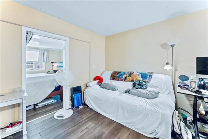Bedroom with cooling unit and wood-type flooring