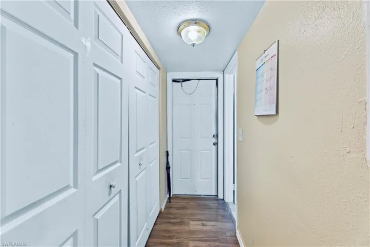Corridor featuring dark hardwood / wood-style flooring and a textured ceiling