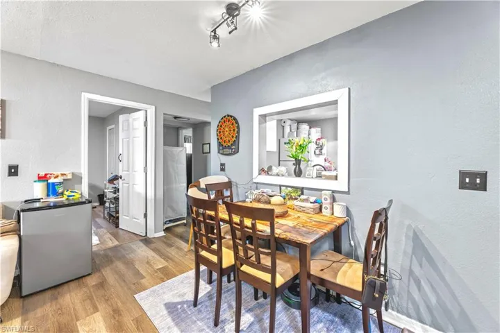 Dining room featuring a textured ceiling, track lighting, and hardwood / wood-style floors